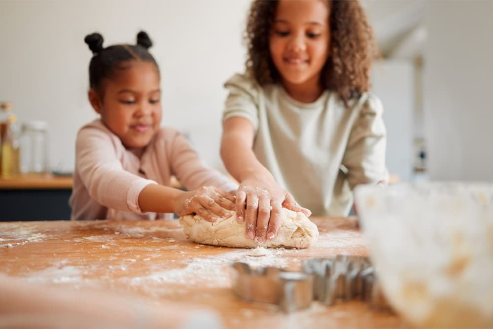 Two children making cookie dough for life skills development at Heartland Ranch.