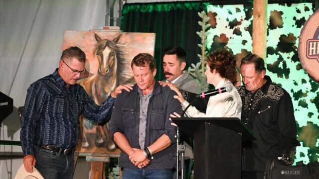Group of people praying over Tim Ballard at Hope For Little Hearts Fundraiser